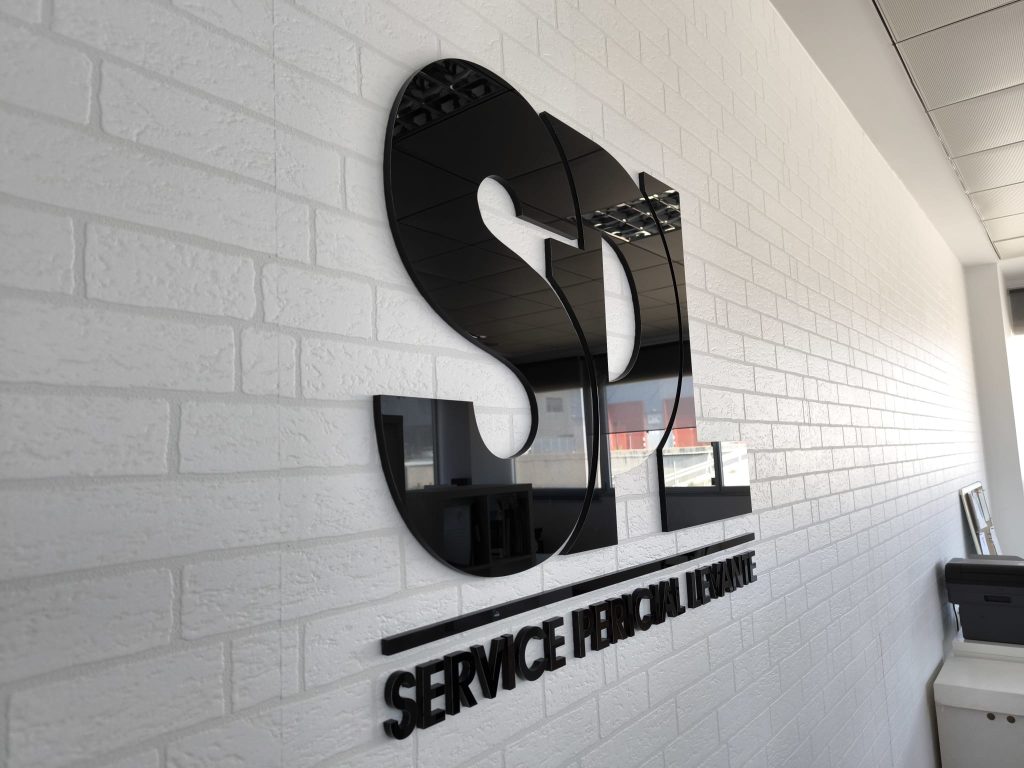 Letras corpóreas de aluminio instaladas en fachada comercial en Alzira