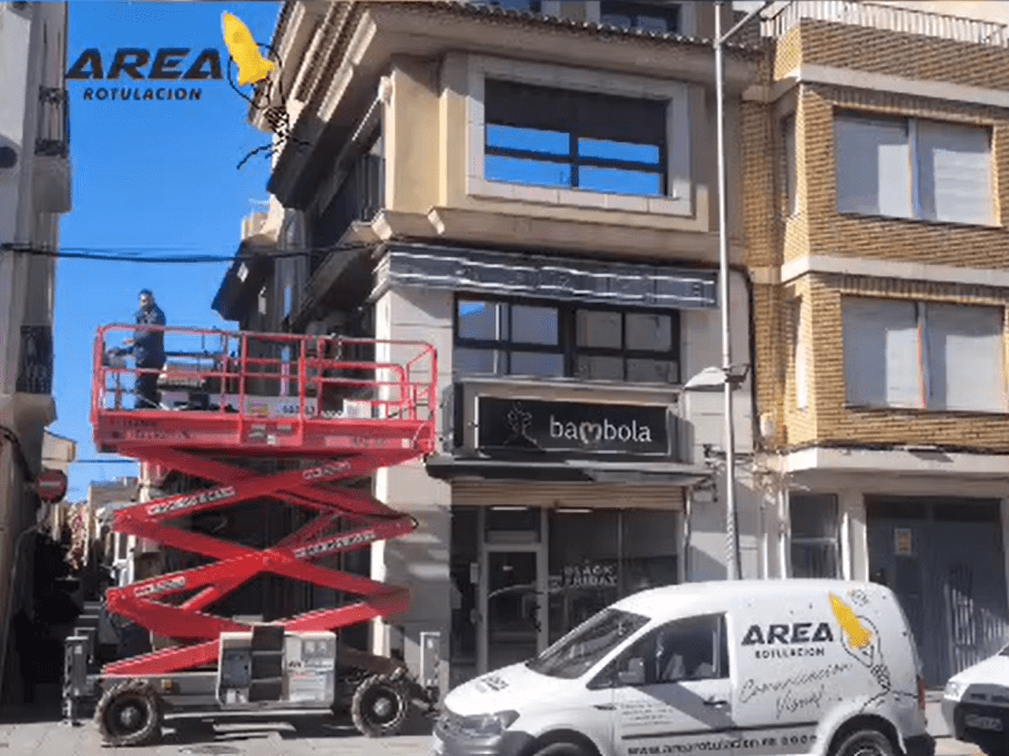 Trabajador en elevador, edificio comercial.